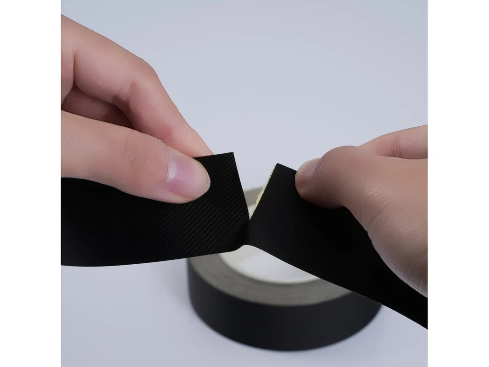 Hand tearing a cloth tape sample